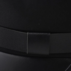 Macro shot of black wool felt and litchi grain leather textures on the sailor cap