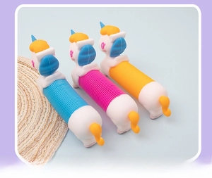 Three colorful unicorn pop tube sensory toys in blue, pink, and yellow on a light blue background