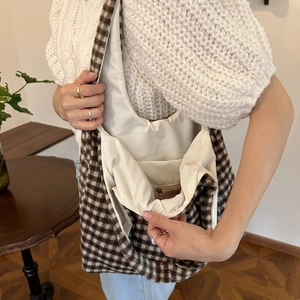Detail view showing the plaid wool tote bag interior lining and practical zipper pocket