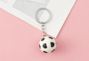 Detailed close-up of a classic 3D black and white football keychain with a silver ring
