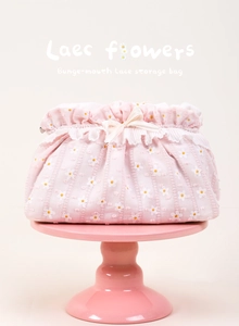 Detail of pink daisy floral makeup bag with white lace trim and satin ribbon bow