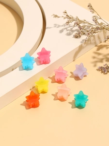 Macro view of colorful jelly mini star hair claws arranged on elegant studio props