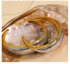Macro detail of two-tone gold and silver bangle featuring elegant water drop accents