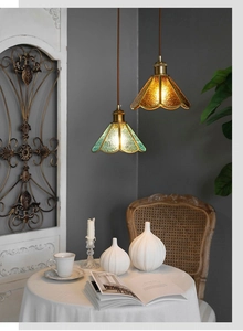 Dettaglio di lampade a sospensione vintage in vetro a petalo con finiture ambrate
