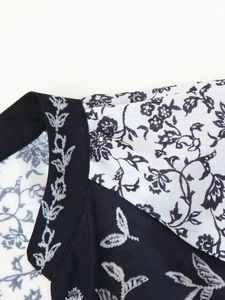 Vue détaillée de l'encolure et de l'épaule montrant les motifs floraux noirs et blancs