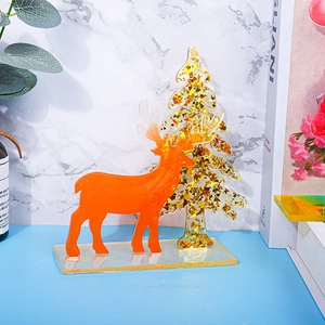 Detailed view of handmade resin Christmas deer and golden glitter tree ornament