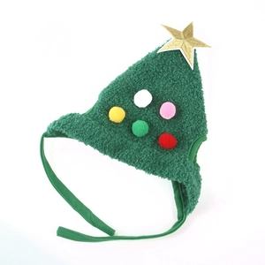 Detail of Christmas tree pet hat with golden star and colorful plush balls on forest green fabric