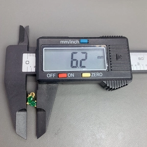 Detailed caliper measurement showing the 6.2mm width of the golden butterfly charm