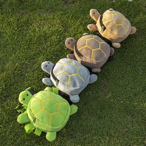 Turtle shaped plush pet backpack in four colors displayed on green grass for dogs and cats