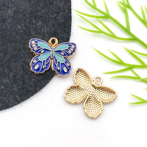 Macro detail of enamel butterfly pendant with blue patterns and golden textured back