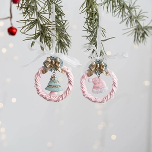 Gros plan de couronnes de Noël roses en résine avec sapin et chapeau sur des branches