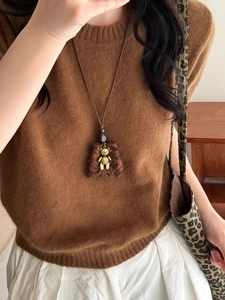 Detail of a brown plush pendant necklace featuring a gold metal bear for autumn and winter