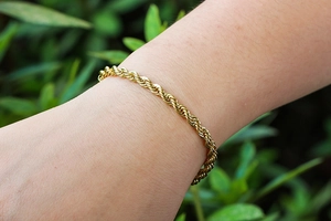 Minimalist 4mm gold rope chain bracelet for men and women on a wrist with nature background