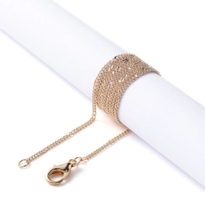 Close-up of a gold fine chain necklace wrapped on a pedestal with a lobster clasp