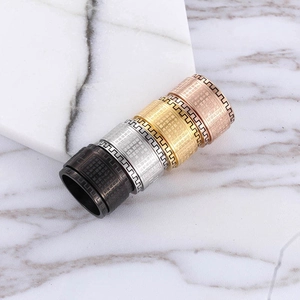 Detailed close-up of rotating mantra rings in four colors on a marble surface