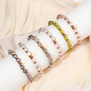 Colorful natural stone beaded bracelets set with heart charms on a silk background