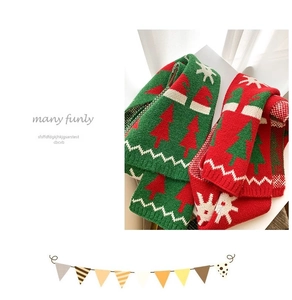 Close-up of red and green knitted kids' scarves with Christmas tree and snowflake patterns