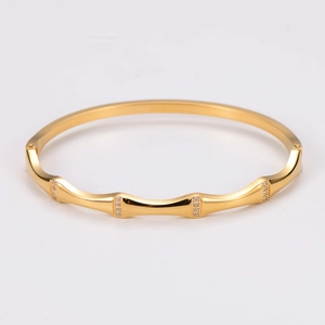 Detailed view of golden bamboo-style bangle with fine crystal-studded hinge detail