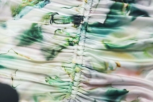 Macro shot of satin fabric with floral print and ruched detail on a long dress set