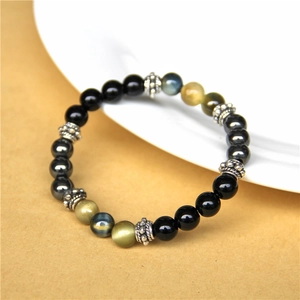 Macro detail of natural tiger eye and black agate beads on a stylish elastic bracelet