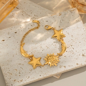 Golden sun moon and star celestial bracelet displayed on natural beige stone background