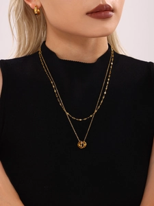Model wearing gold triple-interlocking ring necklace with multi-color cubic zirconia set
