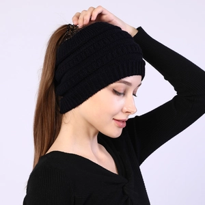 Side view of black knitted headband for women showing elastic texture and ponytail opening