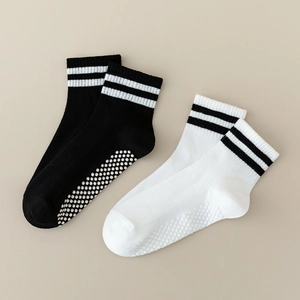 Detail of non-slip silicone grip dots on cotton baby socks with striped cuff