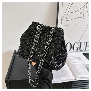 Close-up of black sequined bucket bag with a silver chain strap and shiny texture