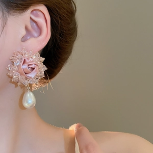 Detail of pink fabric rose earring with crystal beads and a teardrop pearl on model