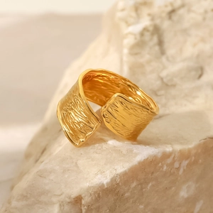 Minimalist 18K gold-plated stainless steel ring with a hammered texture on natural stone