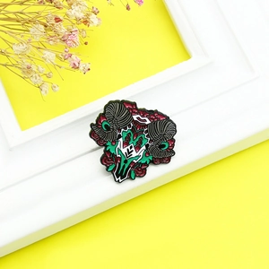 Close-up of alloy ram skull enamel brooch with red roses on a bright yellow background