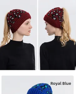 Detail view of leopard print knit beanie with ponytail opening and ribbed cuff finish
