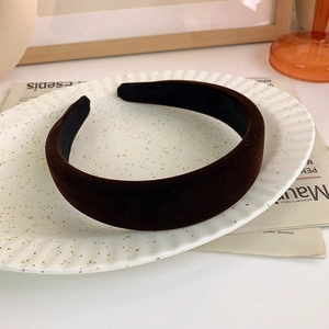Detailed view of dark brown velvet wide headband on a vintage decorative porcelain plate
