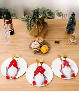 Close-up of festive Christmas gnome cutlery holders set on a white ceramic plate