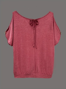 Détail du t-shirt rouge à épaules dénudées montrant le nœud au cou et les boutons métalliques