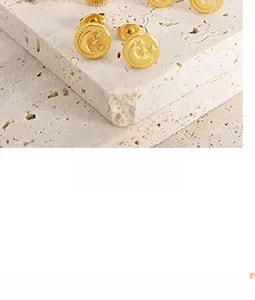 Detailed view of gold round stud earrings with embossed celestial moon and star patterns