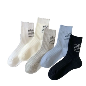 Five pairs of crew socks in white, beige, grey, blue, and black with letter patterns