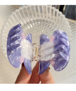 Macro view of purple acetate bow hair claw clip with elegant marble texture effect