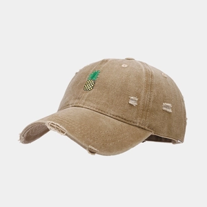 Gros plan sur la casquette en coton vieilli avec broderie ananas et détails usés