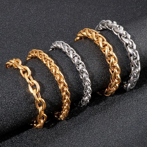 Macro shot of silver and gold woven curb chains on a black textured background