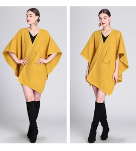 Detail view of stylish yellow knit poncho cape with modern loose fit for women