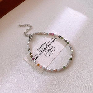 Macro detail of multi-colored stone beaded bracelet with silver spacers and lobster clasp