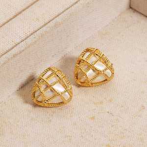 Macro detail of triangle woven 18K gold earrings with white enamel pearl insets