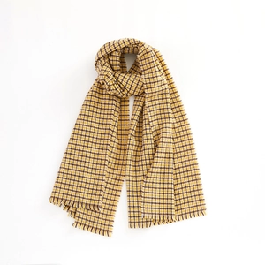 Detailed view of yellow and brown houndstooth pattern scarf with soft fringe tassels