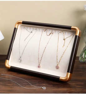 Walnut wood jewelry tray detail showing multiple hooks and champagne gold corners