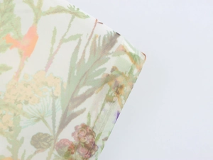 Vue détaillée en gros plan du tissu organza avec imprimé floral délicat et texture fine