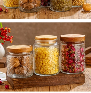 Detailed view of three embossed glass storage jars with bamboo lids on a wooden tray