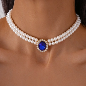 Detail of double-layer pearl necklace featuring a blue gemstone pendant with diamond halo