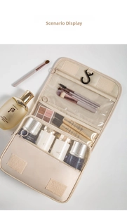 Close-up of beige hanging toiletry bag with multiple compartments and swivel hook